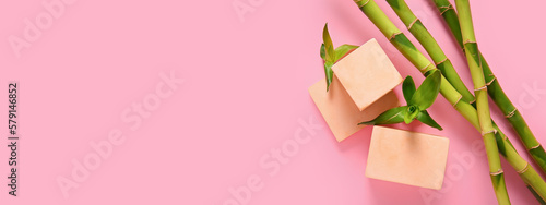 Empty podiums with green bamboo branches on pink background with space for text