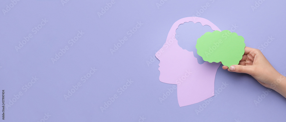 Female hand with paper human head and brain on color background with space for text. Neurology concept Female hand with paper human head and brain on color background with space for text. Neurology concept