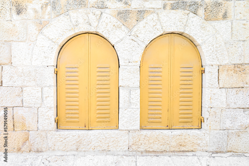 View of old building with yellow window shutters View of old building with yellow window shutters