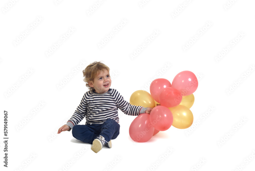 front view of baby boy playing with a air balloon on ground on white background front view of baby boy playing with a air balloon on ground on white background