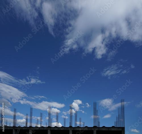 iron chain among metal fittings and concrete pillars against a blue sky with clouds. Construction site. new building house, pouring monolithic walls, metal fittings.