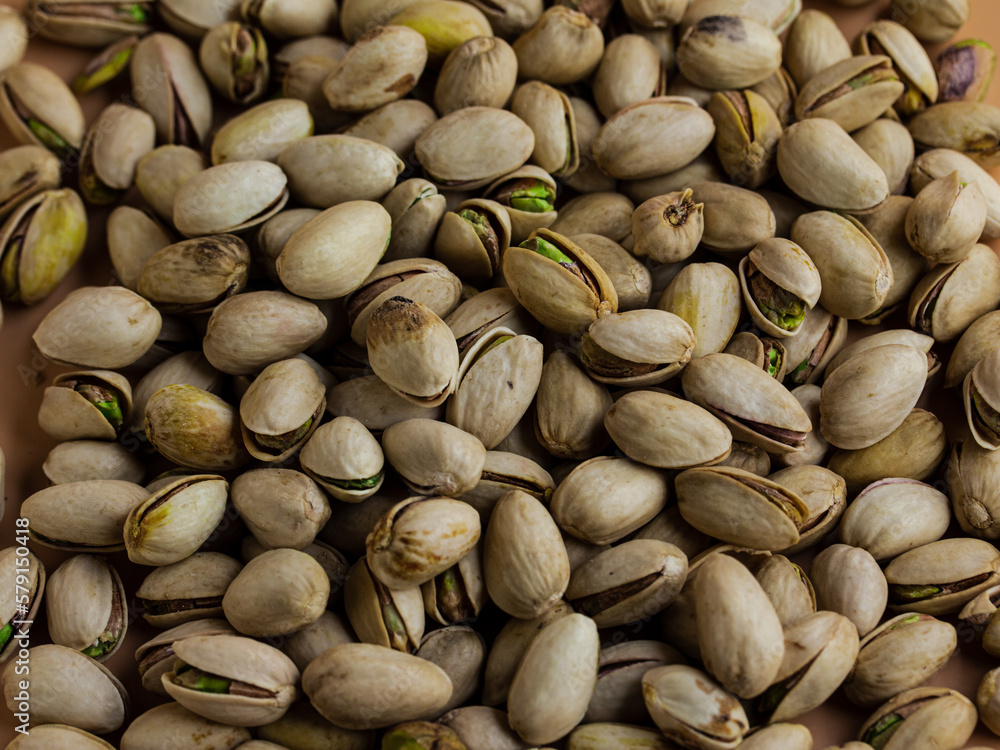 pistachio nuts in shell in a cream color background