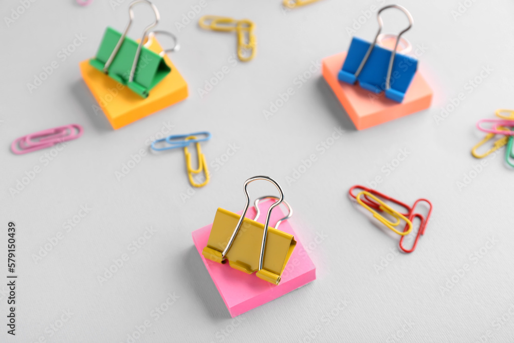 Obraz premium Binder clips and sticky notes on grey background