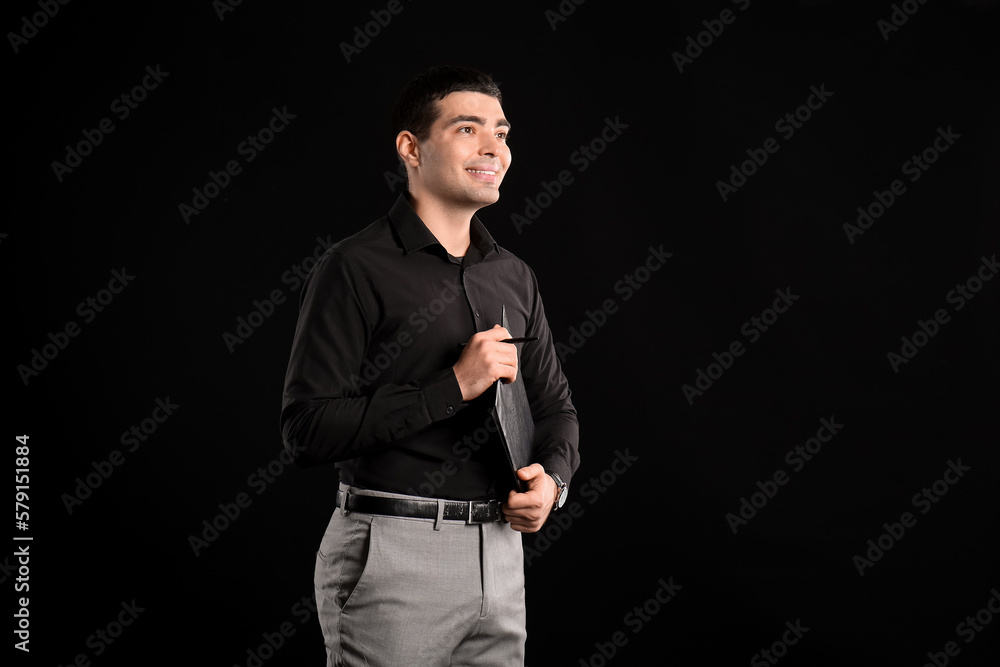 Business consultant with clipboard on dark background