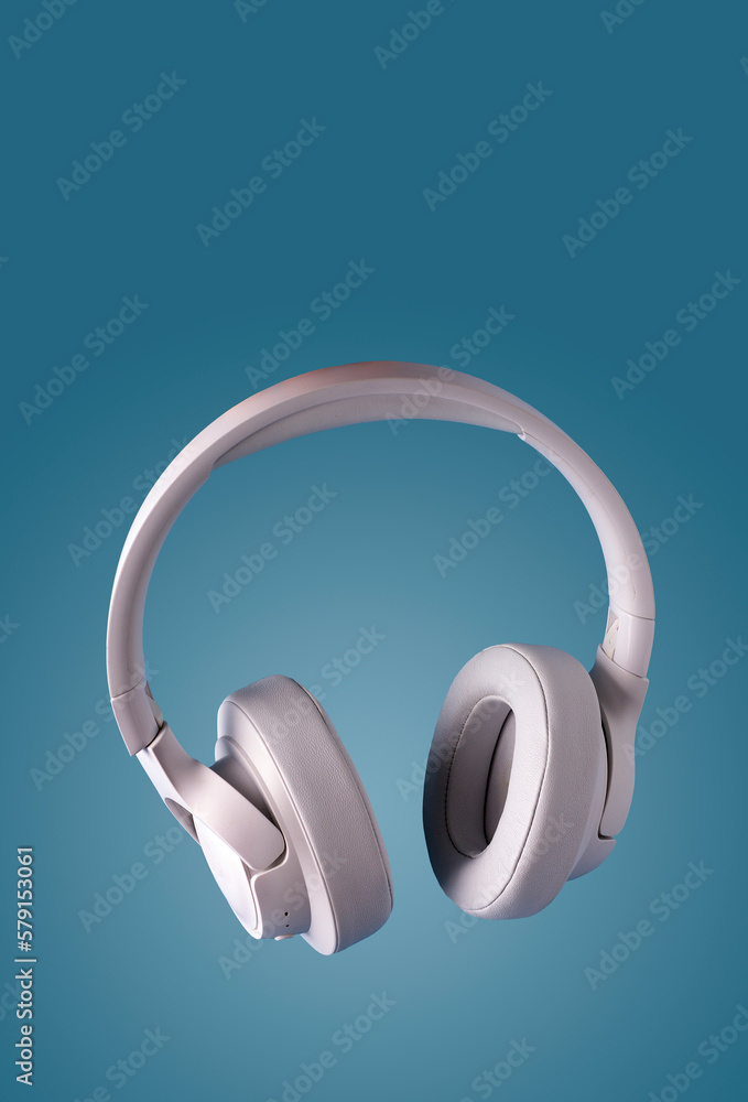 white leather headphones on a blue background, copy space white leather headphones on a blue background, copy space