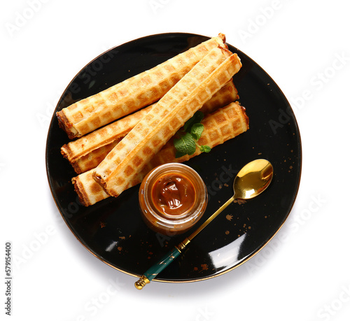 Plate of delicious wafer rolls with boiled condensed milk isolated on white background photo