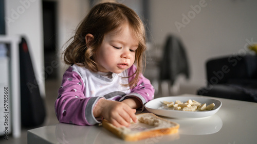 one girl small caucasian toddler female child eat at the table at home