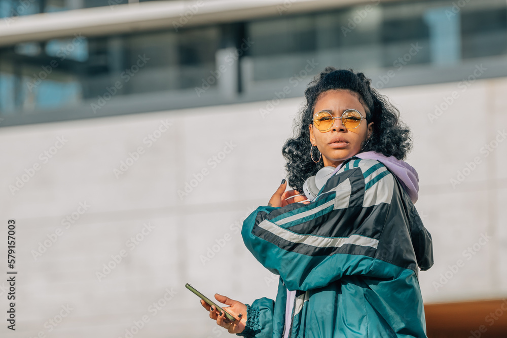 Obraz premium modern urban woman with mobile phone on street