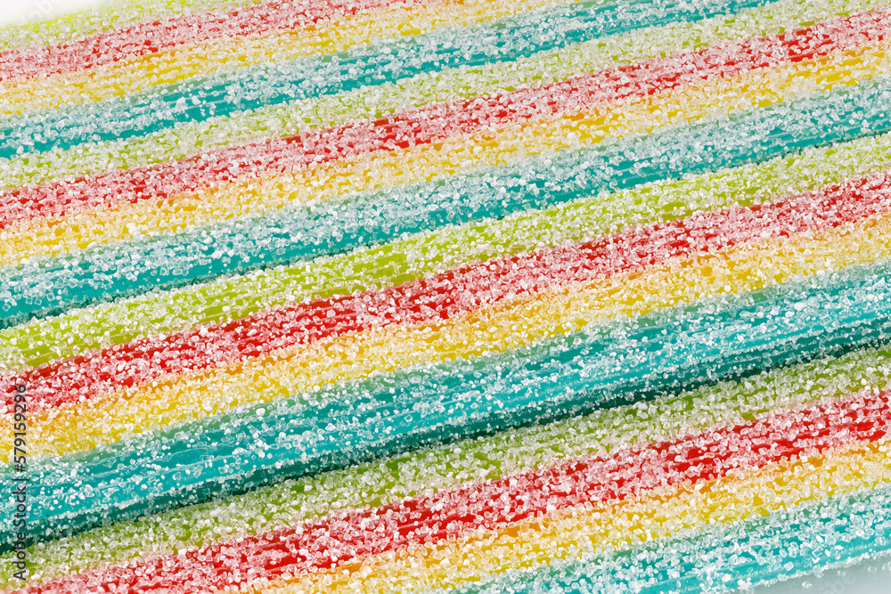 Background of rainbow sour jelly candies strips in sugar sprinkle. Top view, copy space. Close-up.