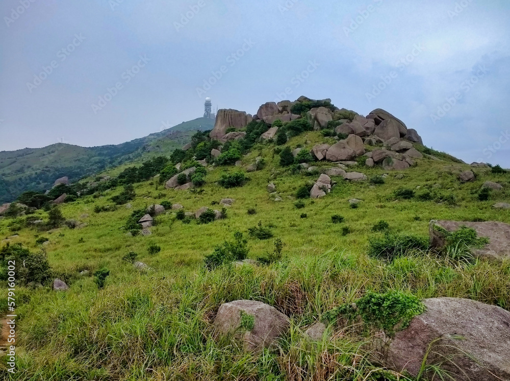 View of nature, rocks and mountains in Tai Mo Shan Country Park. Observatory in the background. Hong Kong. China. Asia