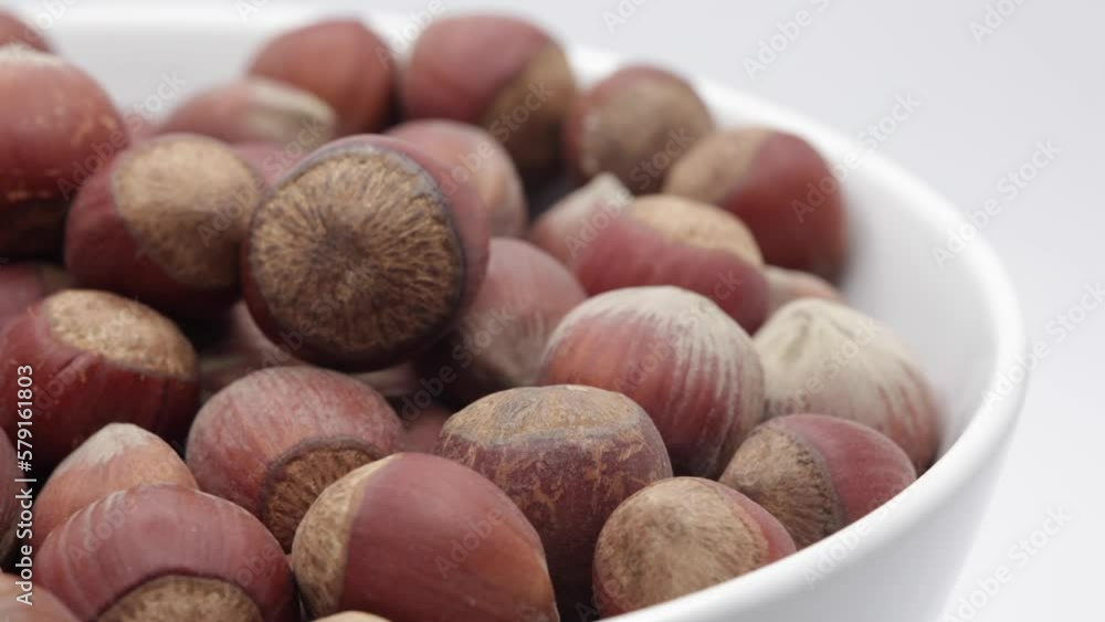 A Bowl Of Hazelnuts On A White Background Rotates. Horizontal Half Frame. 4k, 60 FPS A Bowl Of Hazelnuts On A White Background Rotates. Horizontal Half Frame. 4k, 60 FPS