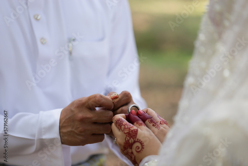 bride and groom holding hands in a ring. Selective focus
