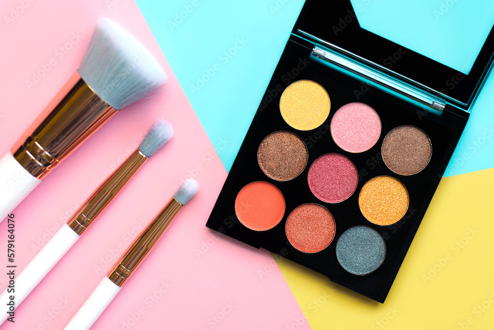 Top view of makeup brushes and eyeshadow and contouring palette. Beauty and makeup concept Top view of makeup brushes and eyeshadow and contouring palette. Beauty and makeup concept