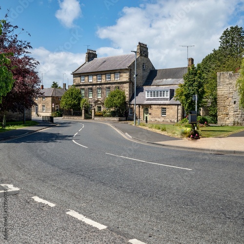 old english village and road surrounded by buildings and green trees