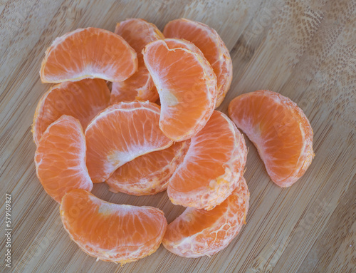 Sliced tangerine on a wooden cutting board closeup