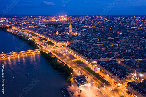 Aerial view of Bordeaux cityscape on banks of Garonne river and Pont de pierre at night