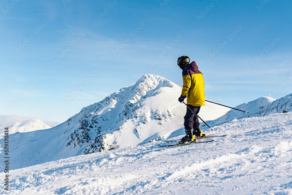 unrecognizable person in yellow clothing practicing skiing on a slope. Mountain and winter sport