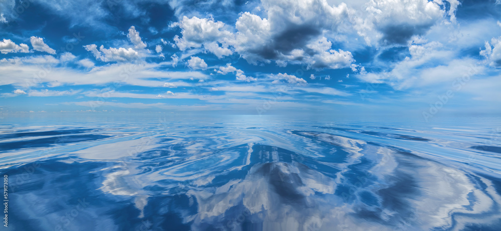 Cumulus clouds reflected on smooth, calm water