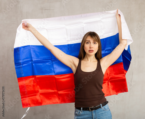 Young sad pretty woman posing tensely with flag of russia photo