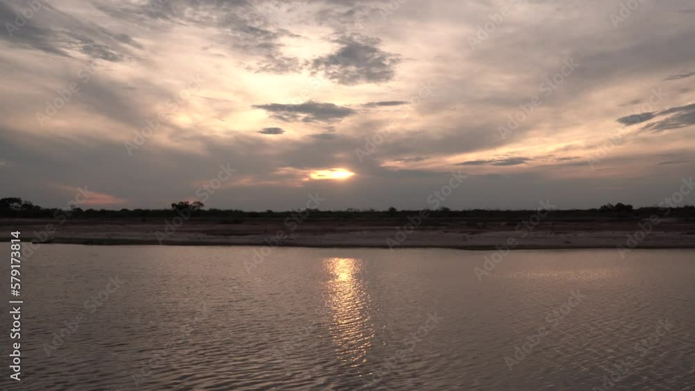 Panorama view of the river under a dramatic sunset sky with beautiful clouds. View of the landscape reflection in the water. Panorama view of the river under a dramatic sunset sky with beautiful clouds. View of the landscape reflection in the water.
