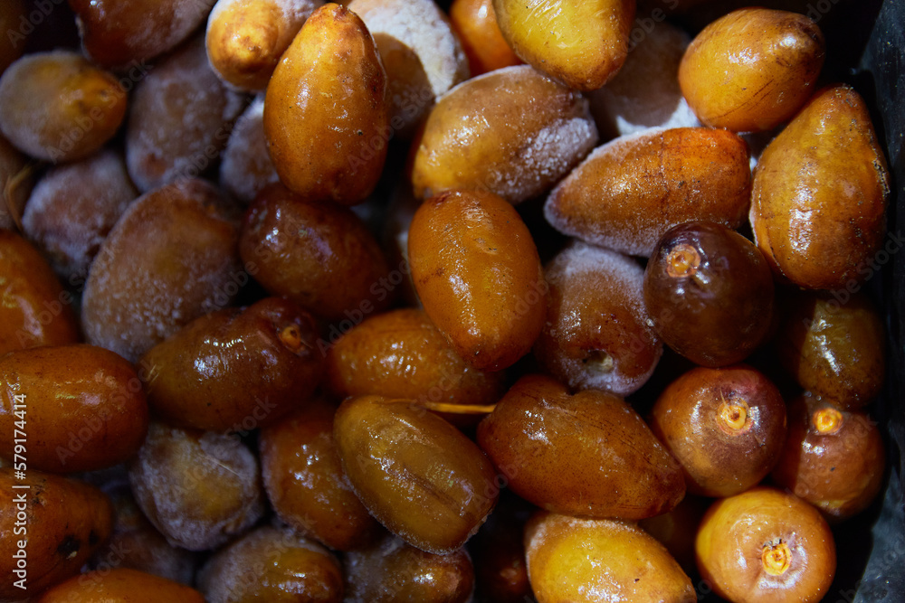 Frozen fresh dates texture pattern. Flat lay top veiw healthy snack. Fruits in the street bazaar Frozen fresh dates texture pattern. Flat lay top veiw healthy snack. Fruits in the street bazaar