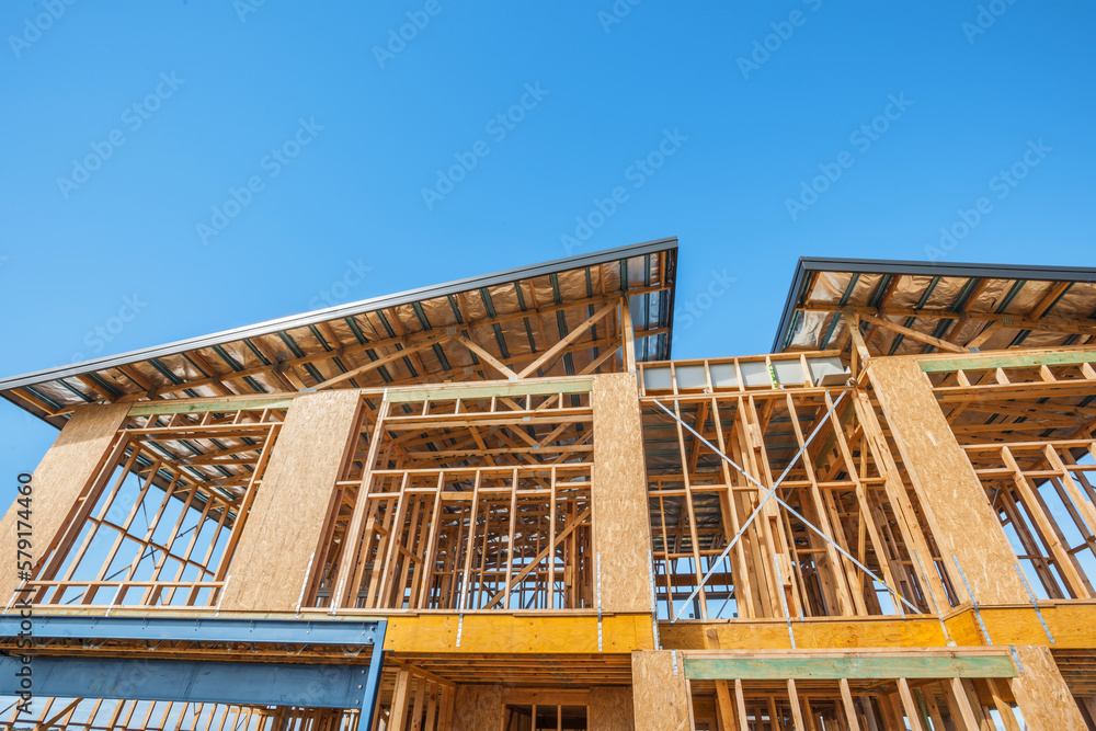 Obraz premium A timber house under construction beneath a clear blue sky