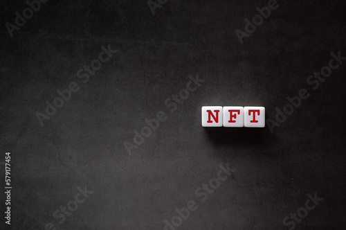 There is white cube with the word NFT. It is an abbreviation for Non-Fungible Token as eye-catching image.