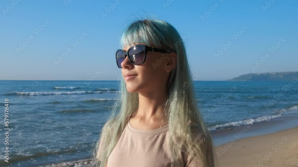 Traveler relaxing on the bay with bracelet. A smiling girl traveler walking along the sea shore with her friendship bracelet under sun. Traveler relaxing on the bay with bracelet. A smiling girl traveler walking along the sea shore with her friendship bracelet under sun.