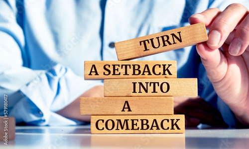 Tableau sur toile Close up on businessman holding a wooden block with Turn a setback into a comeb