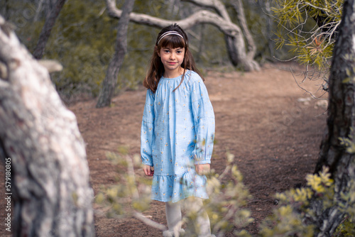 Niña paseando por el bosque mirando a su alrededor 