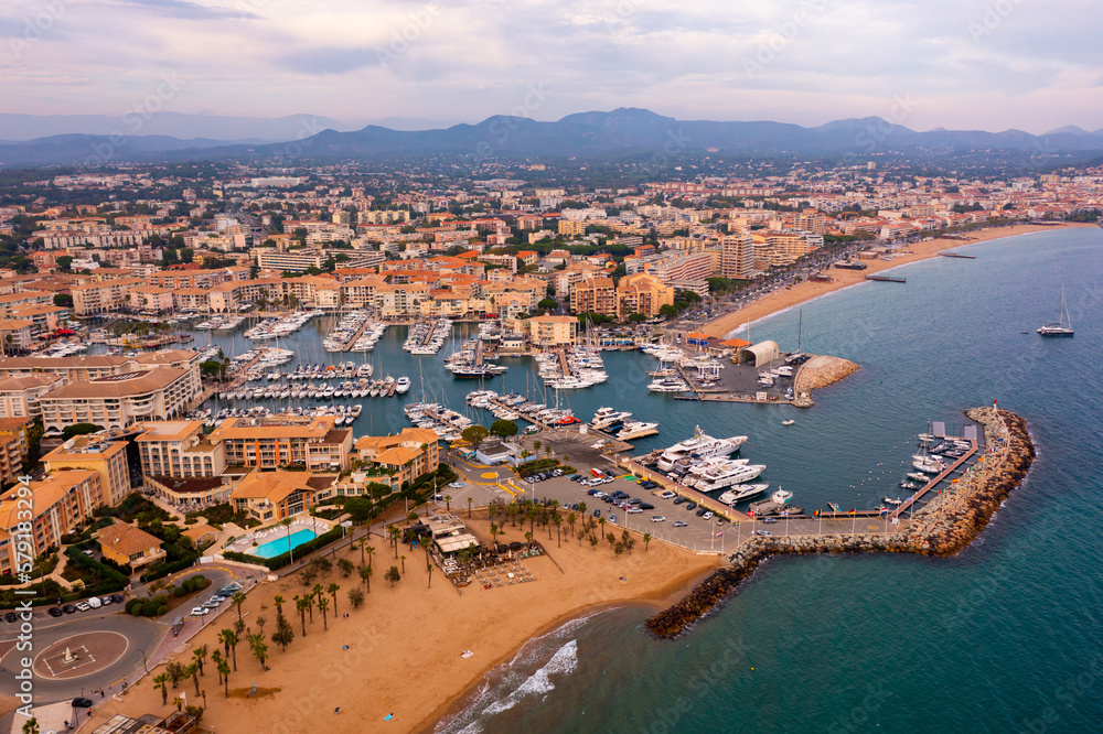 Aerial panorama of Frejus cityscape and vessels in harbor, France