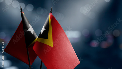 Small flags of the East Timor on an abstract blurry background