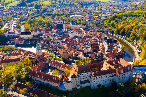 Scenic view from drone of old part of Czech town of Cesky Krumlov with brownish tiled roofs of houses, medieval Castle and Cathedral of Saint Vitus..