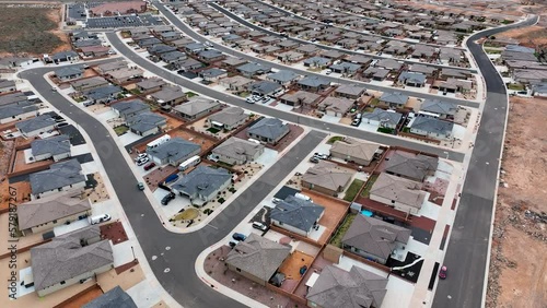 Aerial desert home neighborhood Hurricane Utah. Aerial subdivision residential homes. Desert mountain valley homes, and desert field. Schools, parks, church and public streets and roads. Housing boom.