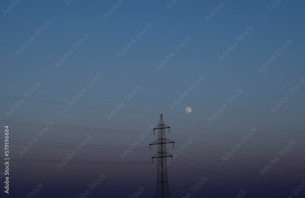 Electricity tower with full moon