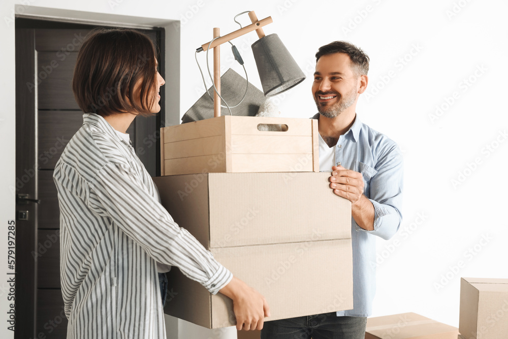 Happy couple with moving boxes entering in new apartment Happy couple with moving boxes entering in new apartment