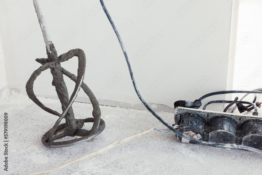 Power mixer on floor near wall indoors. Tiles installation process