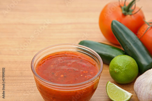 Tasty salsa sauce and different ingredients on wooden table, closeup. Space for text