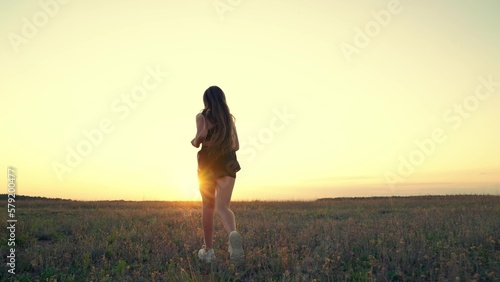 Free young woman runs in spring in park at sunset. Active healthy girl is engaged in fitness, jogging in sun, Running after sun. Training jogging. Jogger girl breathes fresh air on field. Slow motion © zoteva87