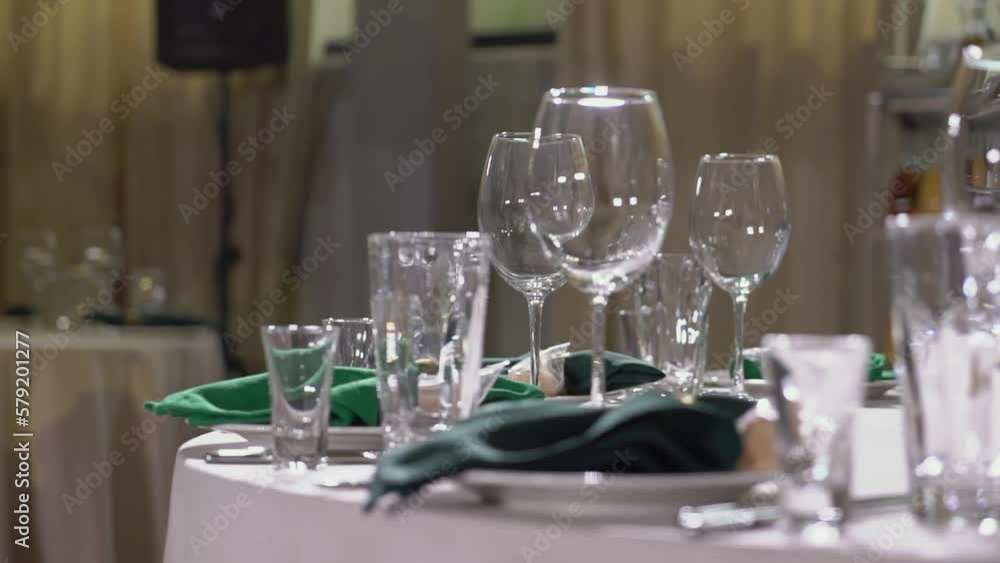 Served tables for a holiday in a restaurant. Glasses, plates, cutlery, napkins. Wedding decor, celebration dinner or party, reception indoors. No food. Served tables for a holiday in a restaurant. Glasses, plates, cutlery, napkins. Wedding decor, celebration dinner or party, reception indoors. No food.