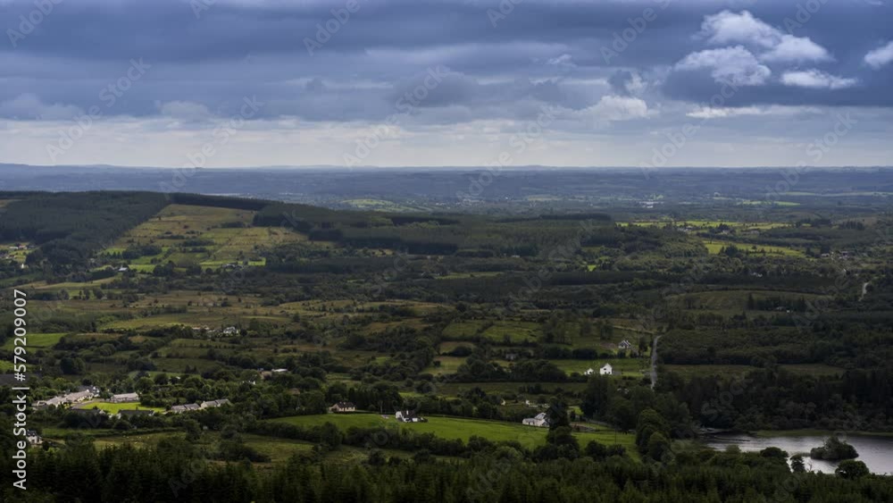 Time lapse of rural farming landscape with lake, forest and hills during a cloudy day viewed from above Lough Meelagh in county Roscommon in Ireland. Time lapse of rural farming landscape with lake, forest and hills during a cloudy day viewed from above Lough Meelagh in county Roscommon in Ireland.