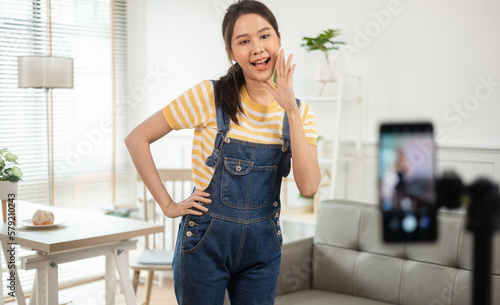 Asian young beautiful woman streamer listening to music dancing and listening music at Home Interior, Residential Building.share video on tiktok social media application photo