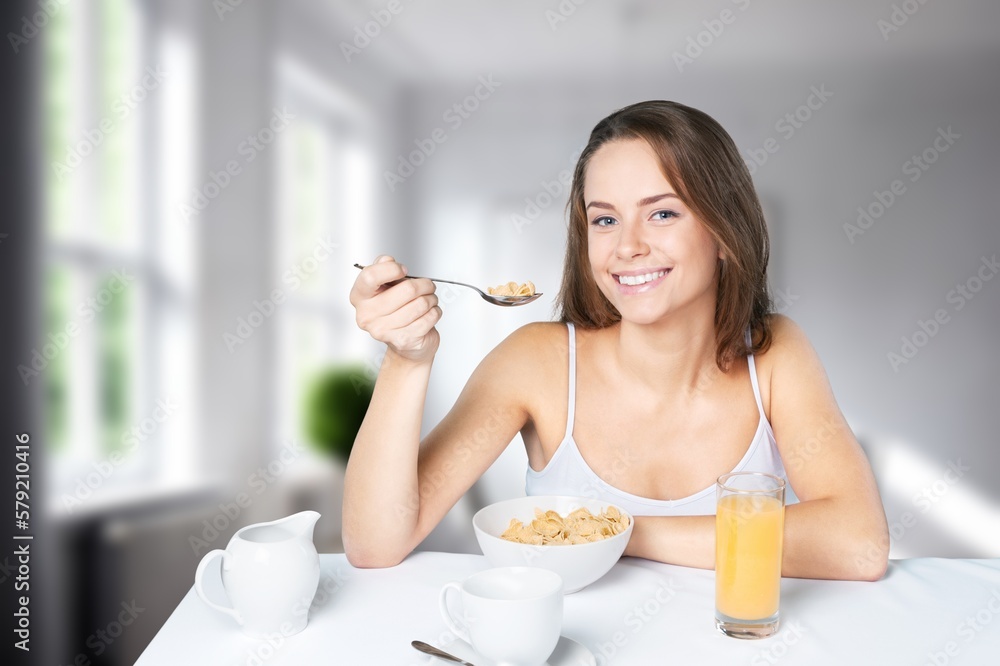 Young happy woman eating dish in kitchen interior Young happy woman eating dish in kitchen interior