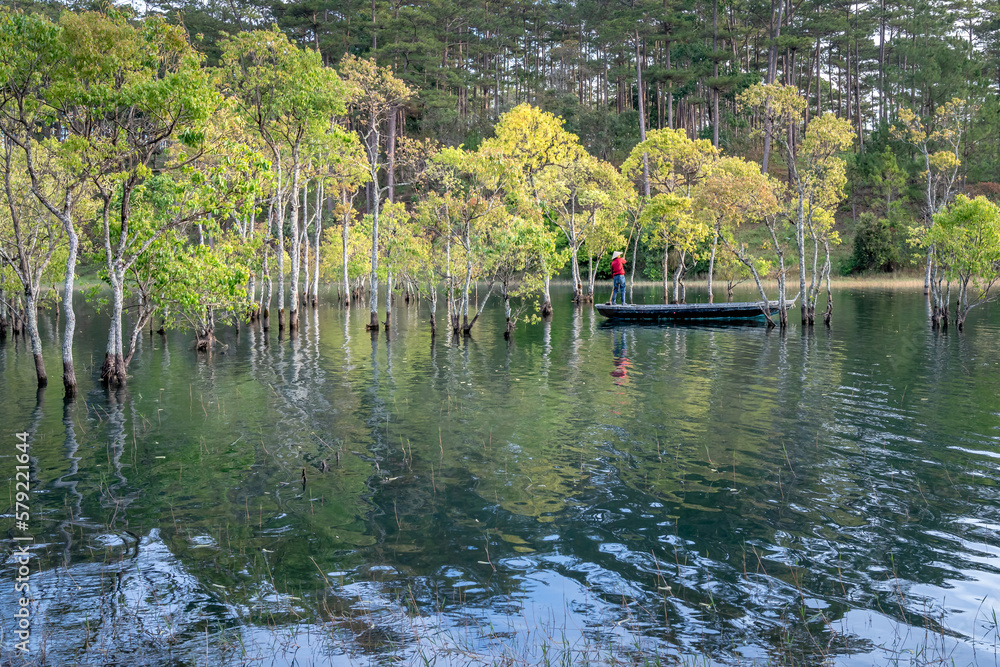 A beautiful view of the lake in Autumn. The reflections of the yellow leaves to water. Photo taken with long exposure technique