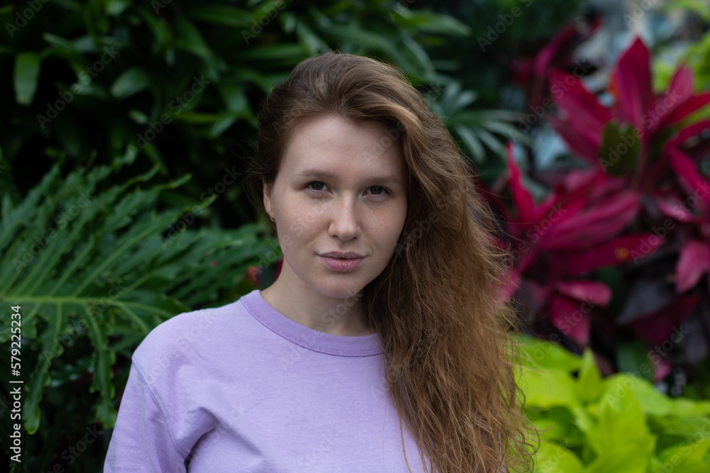 Portrait of happy young woman with breathing deep, inhale fresh air on natural background, green wall with leaves, flower in tropical country in garden. Eco, ecological concept. Portrait of happy young woman with breathing deep, inhale fresh air on natural background, green wall with leaves, flower in tropical country in garden. Eco, ecological concept.