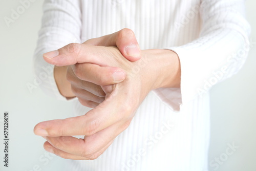 Man massaging thumb and finger pain, trigger finger from work and office syndrome On a white background medical concept