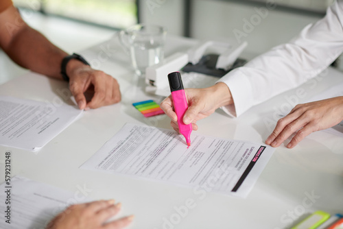 Manager highlighting important part of document with pink color photo
