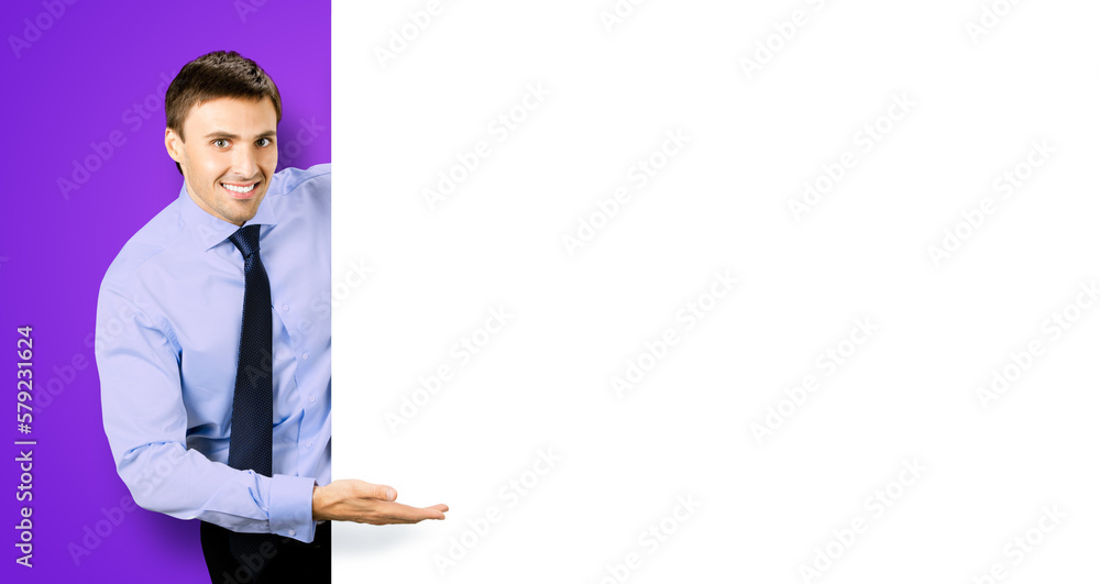 Portrait picture of young business man bank manager in confident cloth, necktie stand behind show empty white banner signboard billboard with copy space text area. Isolated on violet purple background Portrait picture of young business man bank manager in confident cloth, necktie stand behind show empty white banner signboard billboard with copy space text area. Isolated on violet purple background