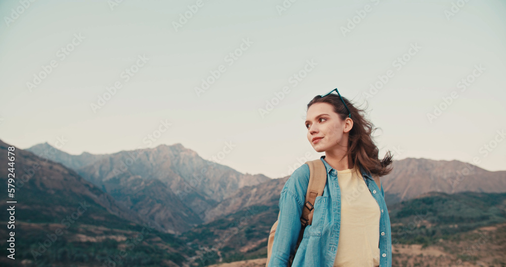 Copy space. Girl traveler with backpack enjoy mountain nature standing on the top. Goals and achievements concept photo composite.