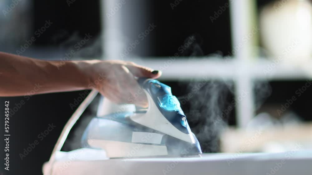 Video Stock Selective focus of female hand irons white clothes with